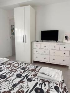 a bedroom with a bed and a dresser with a television at Corte del Gallo in Legnano