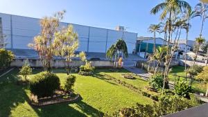 a garden with palm trees in front of a building at Casa temporada in Joinville