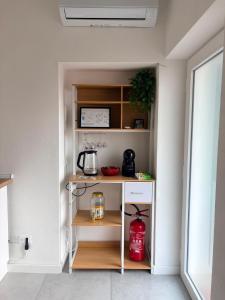 a small kitchen with a shelf with a coffee maker at Corte del Gallo in Legnano