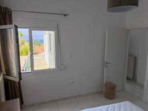 a room with a window and a white wall at Modern Sea View Apartment - Arkitsa Rentals in Arkitsa