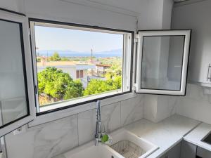 a bathroom with a sink and two windows at Modern Sea View Apartment - Arkitsa Rentals in Arkitsa +16 photos