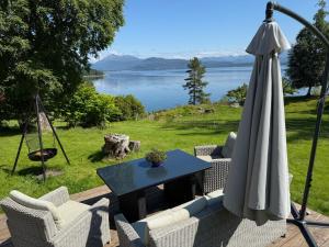 a patio with an umbrella and a table and chairs at Draget gård, idyllisk småbruk ved sjøen in Molde