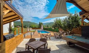 a patio with a pool table and a swimming pool at na obali drine in Perućac