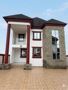 a house with red columns on a brick driveway at Asibbey Lodge in Ashalebotwe