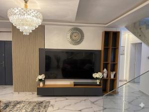 a living room with a fireplace and a chandelier at Asibbey Lodge in Ashalebotwe
