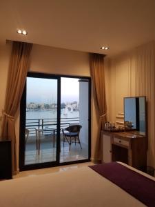 a bedroom with a large window with a view of the water at Nile Castle in Luxor