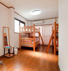 大阪市にあるゲストハウス　ワ　エヌ　ワの二段ベッド2組が備わるウッドフロアの客室です。