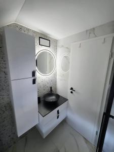 a white bathroom with a sink and a mirror at UP & DOWN Holiday House in Donji Prozor +19 photos