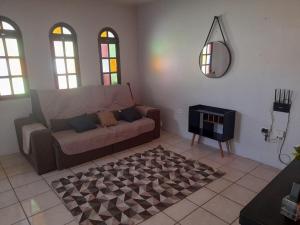 a living room with a couch and a mirror at Casa Vilarejo in Arembepe