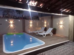 a hot tub on a patio with two chairs at Casa Vilarejo in Arembepe