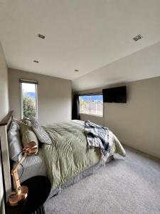 a bedroom with a bed in a room with a television at Spacious Family Home in Te Anau in Te Anau