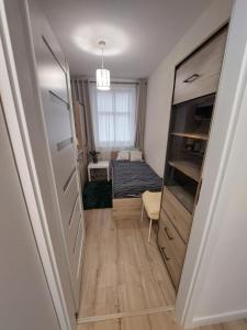 a small room with a bed and a window at Baza Ślęża , Nowoczesny Apartament w sercu Sobótki in Sobótka
