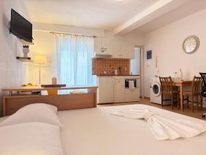 a bedroom with a bed and a kitchen with a table at Studio 28 in Chios