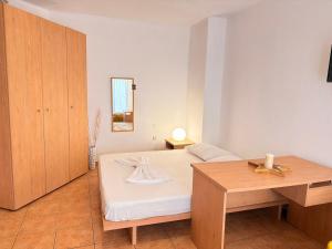 a bedroom with a bed and a wooden table at Studio 28 in Chios
