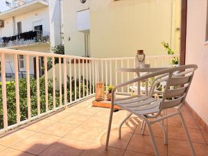 a table and a chair on a balcony at Studio 28 in Chios