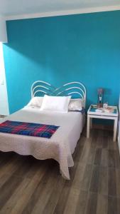a bedroom with a bed and a blue wall at Life Pinhalzinho in Pinhalzinho +24 photos