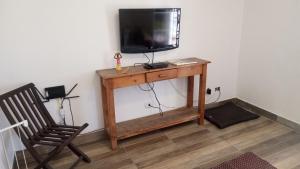 a television sitting on a wooden table with a chair at Life Pinhalzinho in Pinhalzinho