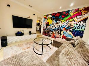 a living room with two couches and a mural at Dreampoolhousemiami in Miami