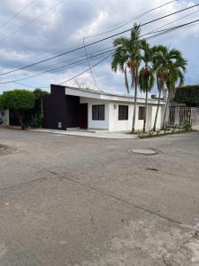 a white building with palm trees in front of it at Cerete Apartment 111 in Cereté