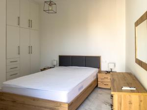 a bedroom with a large bed and a wooden desk at Modern Comfort Apartment - Arkitsa Rentals in Arkitsa