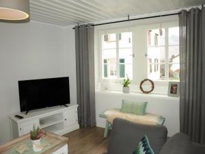 ein Wohnzimmer mit einem Flachbild-TV und einem Fenster in der Unterkunft Ferienhaus N° 14 in Mülheim an der Mosel