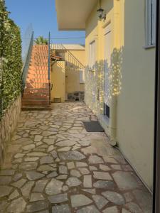 a stone walkway next to a building with a gate at Modern Comfort Apartment - Arkitsa Rentals in Arkitsa