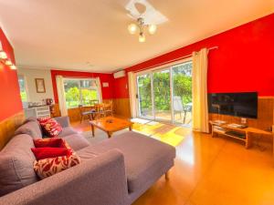 a living room with a couch and a flat screen tv at Relax a Lodge in Kerikeri
