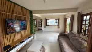 a living room with a couch and a flat screen tv at Recanto HipoMar in Marechal Floriano
