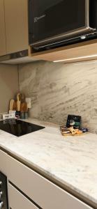 a kitchen counter with a white marble counter top at Apê Brisa-5min consulado EUA-garagem in Porto Alegre