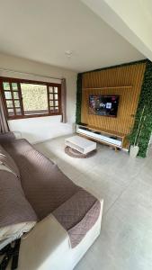 a living room with a large bed and a flat screen tv at Recanto HipoMar in Marechal Floriano +19 photos