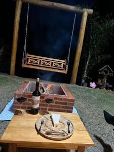 a table with a glass of wine and a fire place at Recanto HipoMar in Marechal Floriano