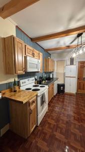 a kitchen with wooden cabinets and a white stove top oven at Cozy Oneonta Getaway in Oneonta