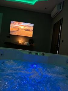 a bedroom with a tub with a tv on the wall at Boutique Hotel Mare in Middelburg
