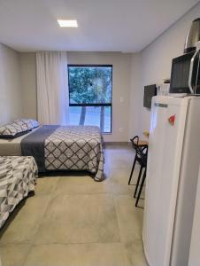 a room with two beds and a refrigerator at Villa Parati Bombinhas Sob Nova Direção in Bombinhas