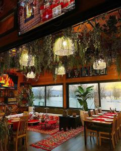 a dining room with tables and chairs and windows at Hysaj Agroturizëm in Shkodër