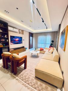 a living room with two couches and a flat screen tv at جناح فاخر بإطلالة على البحيرة وجاكوزي خاص in Al Khobar