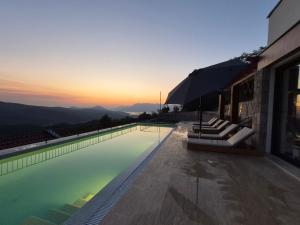 a swimming pool with a sunset in the background at Villa Verdura in Budva +41 photos