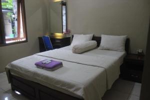 een slaapkamer met een groot bed met een paarse handdoek erop bij Cyka Raya Hotel in Wonosari