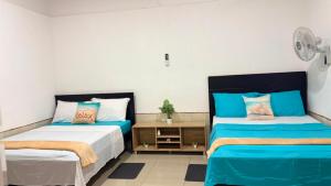 two beds in a room with blue and white at Escápate a Jacó apartamento completo in Jacó