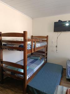 two bunk beds in a room with a tv at Pousada Paraiso in Telêmaco Borba