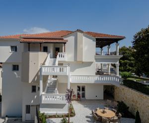 a large white house with a patio and a table at Anema Living in Parga