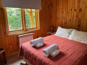 a bedroom with a bed with towels on it at Illihue - Cabañas, Hostería & Spa in Junín de los Andes