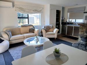 a living room with two couches and a table at Cardrona mountain cottage in Cardrona