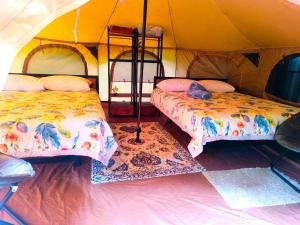 a room with two beds in a tent at Monstera Forest Lodge in Fortuna