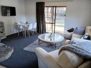 a living room with a couch and a table at Cardrona mountain cottage in Cardrona +2 photos