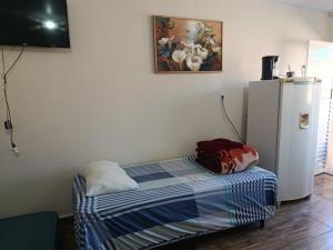 a small room with a refrigerator and a bed at Pousada Paraiso in Telêmaco Borba