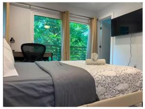a bedroom with a bed and a large window at 1 full bed with En-Suite bath surrounded by greenery in Austin