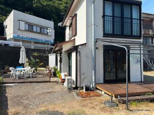 a white house with a deck and a patio at Sea Retreat Nika in Kawazu