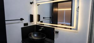a bathroom with a sink and a mirror and a toilet at Aparta Estudios Luz Galery in Bogotá +59 photos