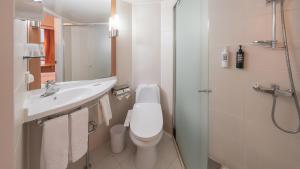 a white bathroom with a toilet and a sink at Central Seven Hotel by Kwon Busan Seomyeon in Busan +50 photos